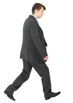 Walking businessman in a dark suit isolated on white background