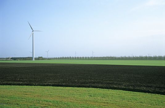 Modern windmills, or wind turbines, dot the lowland countryside of the Netherlands.