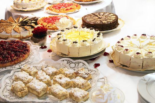 Cake buffet with various cakes decorated with flowers
