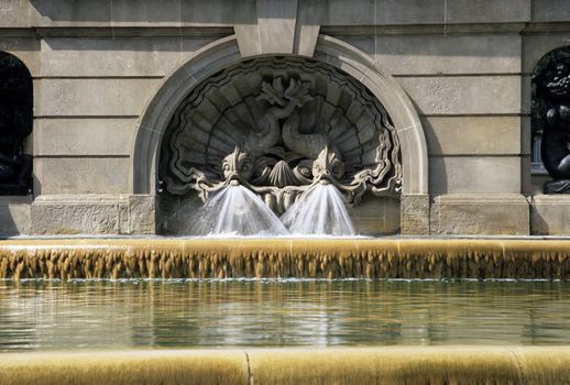 Detail of a fountain in Barcelona, Spain featuring two fish.