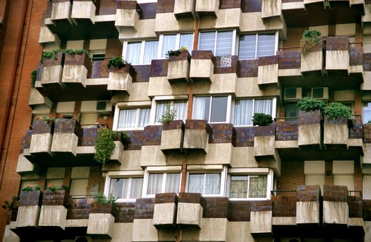 Colourfully tiled balconies are covered with flowers and greenery in Barcelona, Spain.