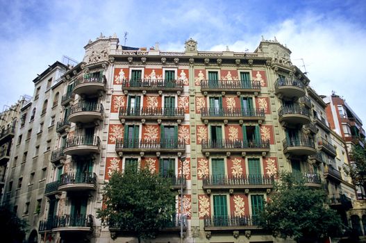 An ornate apartment building stands proudly on a city street in Barcelona, Spain.
