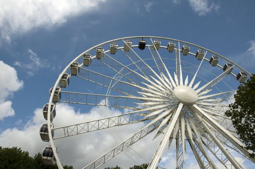 A big ferris wheel with a blue cloudy sky