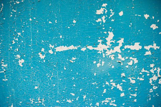 Blue peeling paint on the white wall grunge background