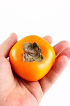 Persimmon in a man's hand removed close up on a white background without isolation