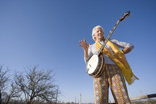 Banjo player standing against the blue sky