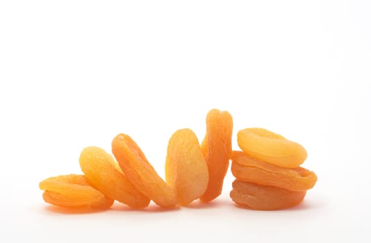 Ginger dried apricots lying in a row on white background