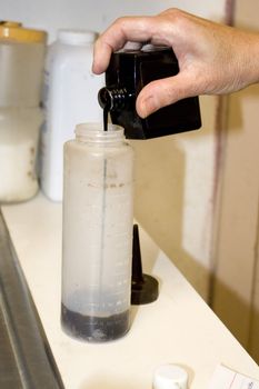 A hairdresser mixing up a hair color formula.