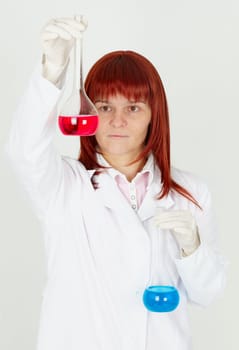 Woman chemist with colored flasks in their hands