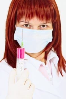 A young woman doctor with a syringe in his hand