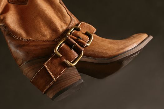 Female boot of the cowboy on a dark background