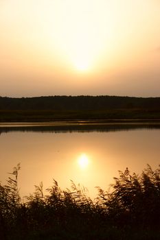Dawn on lake with the sun reflected in water