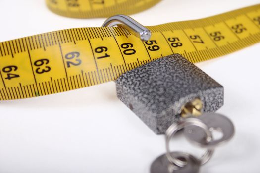 The open padlock on a measuring tape removed close up