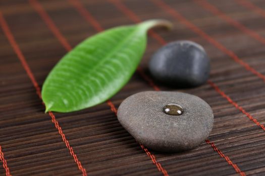 Stones for spa with green sheet on a bamboo napkin removed close up