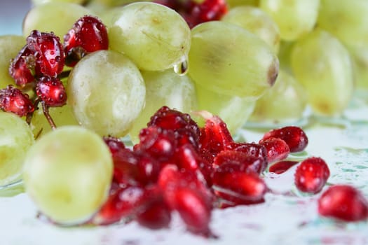 Grapes with pomegranate grains on glass removed close up