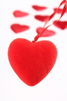 Red plush heart against small hearts removed close up