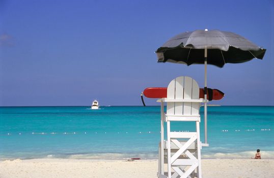 An empty lifeguard chair overlooks rough waters in the Bahamas. 