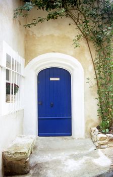 A bright blue door welcomes visitors to a home in the provence region of France.