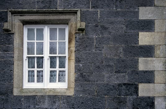 Window with lace curtains at a train station in rural Ireland