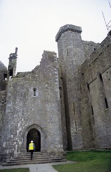 A workman enters the Rock of Cashel ruin which is under reconstruction