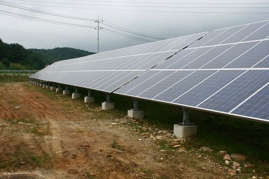 solar power plant with different panels against high tension wires
