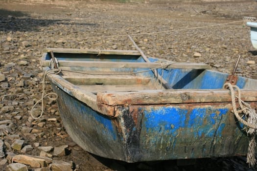 a wooden old boat on the pebble beach
