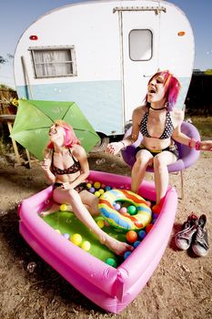 Woman with in an inflatable play pool playing with bubbles