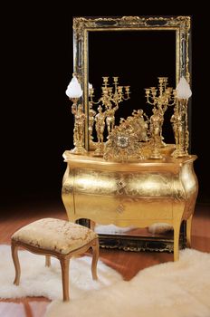 Luxurious bronze interior items. Table, big mirror, lamps, ottoman, clock