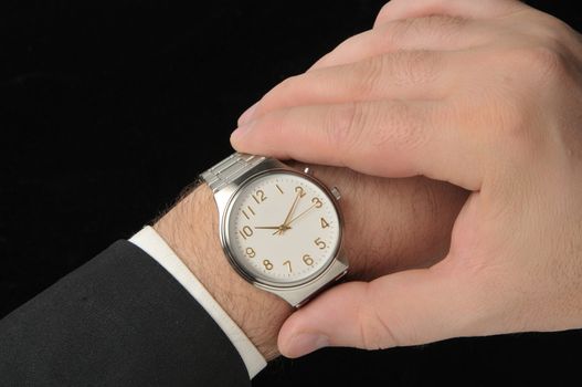 Business man looking at watch. Black Background