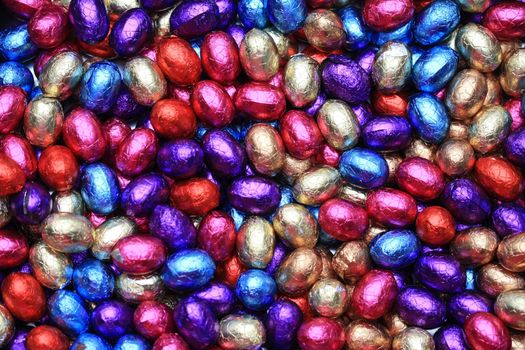 A pile of chocolate easter eggs in different colored wrapping