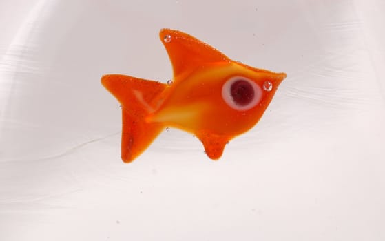 A glass fish incrusted into a solid block of clear glass
