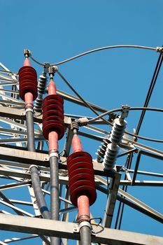 Three red ceramic high-voltage power line fixtures for grounding of the cables
