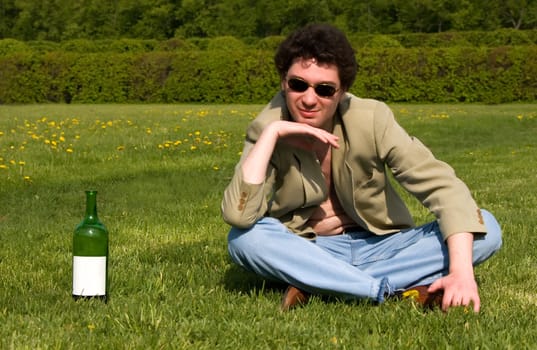 Cheerful drunk man on a meadow