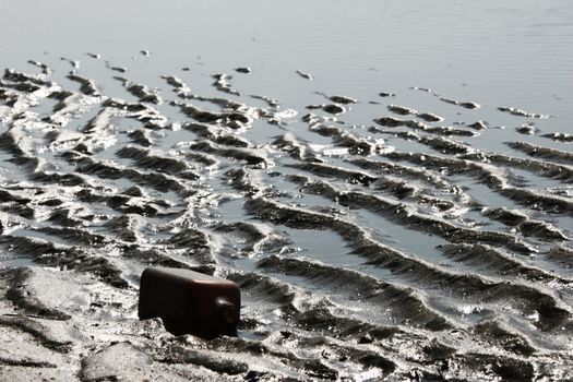 Empty bottle on sea coast.