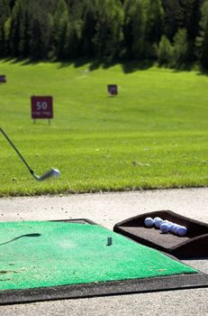 An airborne golf ball just being hit by the club
