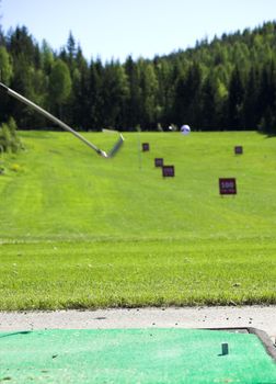 A golf ball and club in action.
