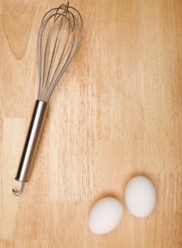 Mixer and Eggs on a wooden background.