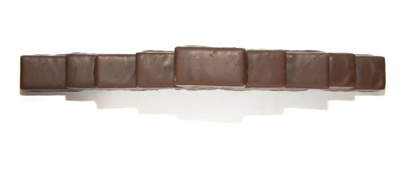 A geometric figure, resembling a double ladder, made from chocolates. Full shadow is visible.
