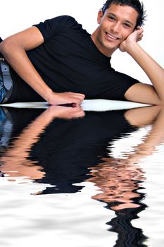 Studio portrait of mixed race young man lying down looking friendly