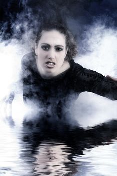Portrait of a woman with long curly hair in smoke