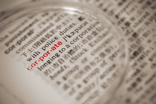 Corporate definition in dictionary with magnifier in yellow color.