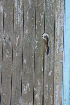 Aged door handle on wooden entrance door