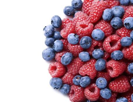 Blueberries and raspberries over white background with copy space