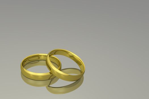 Gold wedding bands on a grey background.