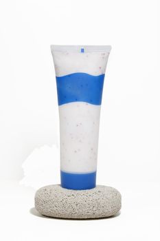 A container of foot lotion and pedicure lava rock.