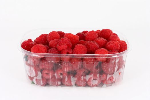 Fresh raspberries in plastic container on white background