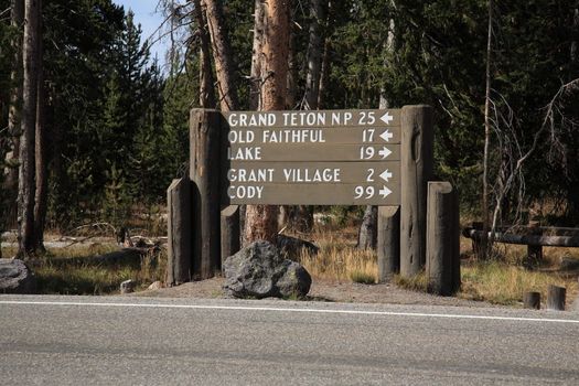 Vintage wooden sign points to Yellowstone attractions