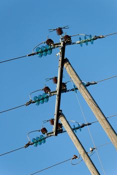 Three power lines, fixed horizontally on a tree pylon. The composition is tilted, so the fixture is vertical
