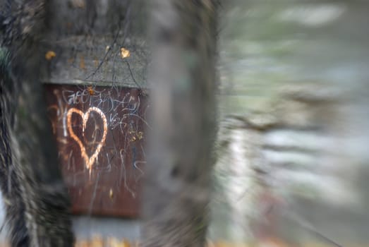 Rusty metal door to a bunker, with a heart tagged on it. The blur effect is achieved in-camera using a Lensbaby.
