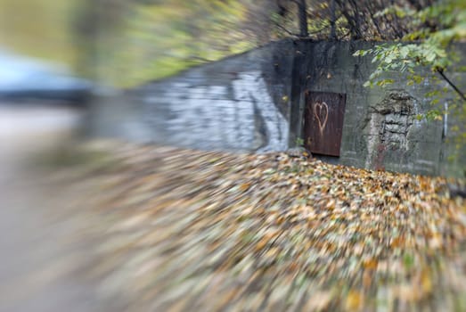 A concrete bunker's wall, partially busted. The blur effect is achieved in-camera using a Lensbaby.
